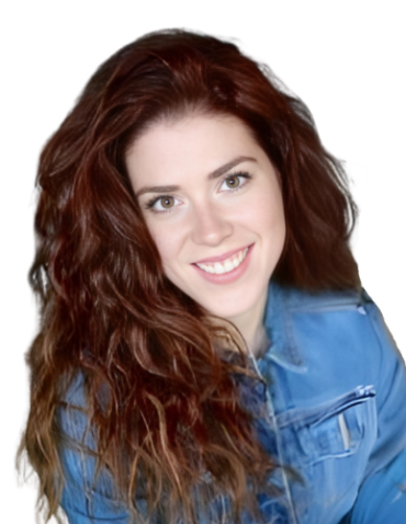 A person with long, wavy reddish-brown hair smiles while wearing a blue denim jacket.