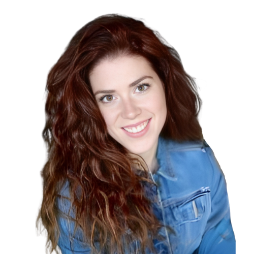 A person with long, wavy reddish-brown hair smiles while wearing a blue denim jacket.